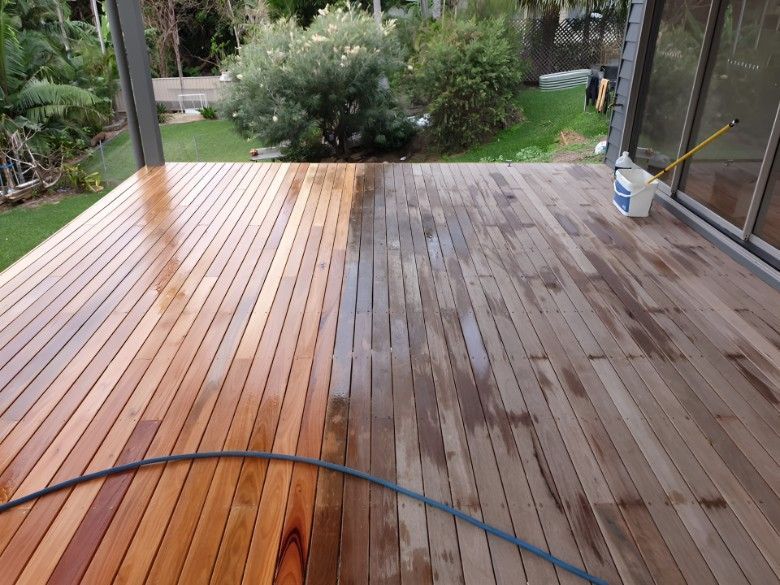 A Wooden Deck is Being Cleaned With a Hose — Let's Paint & Decorate Pty Ltd in Shellharbour, NSW