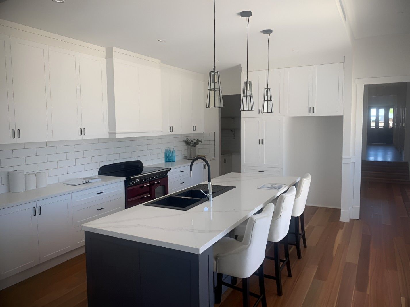 A Kitchen With White Cabinets and a Large Island — Let's Paint & Decorate Pty Ltd in Shellharbour, NSW