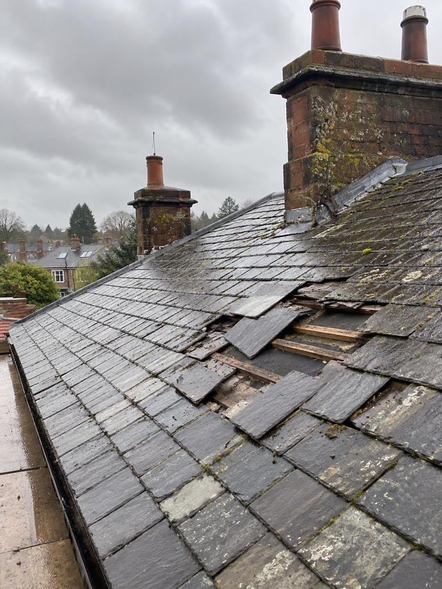 Slate roof with slipped and missing slates before our roofers repaired it