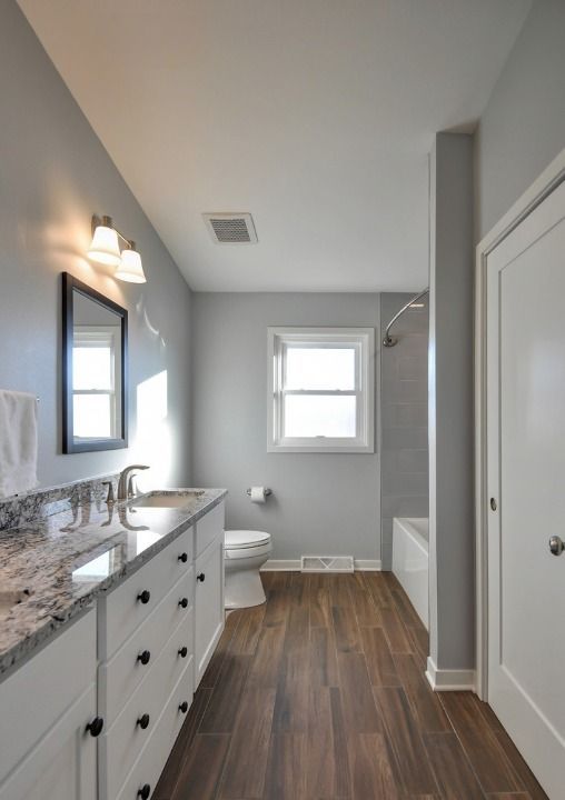 A bathroom with a sink , toilet , shower and window