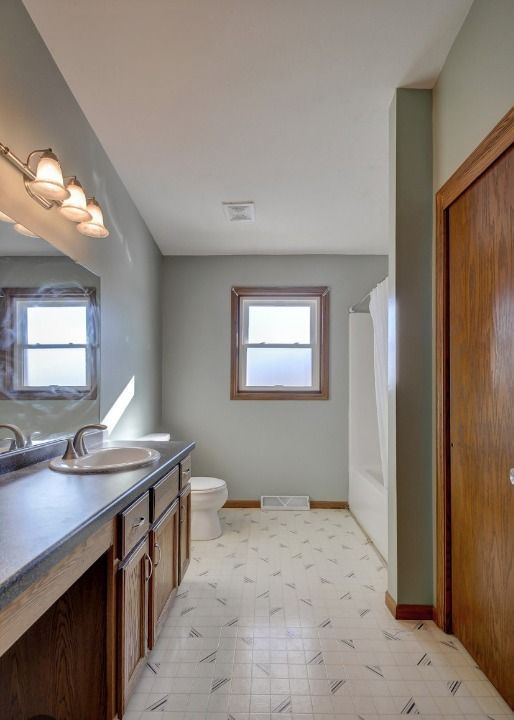 A bathroom with a sink a toilet and a window