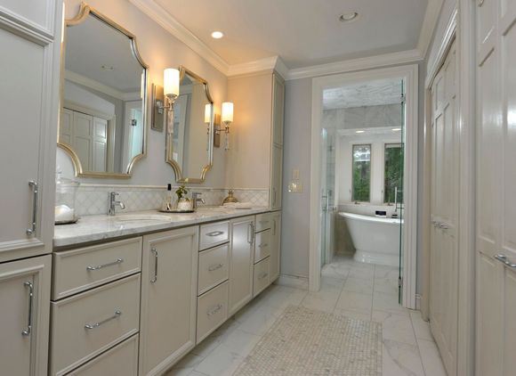 A bathroom with pink walls and a white bathtub.