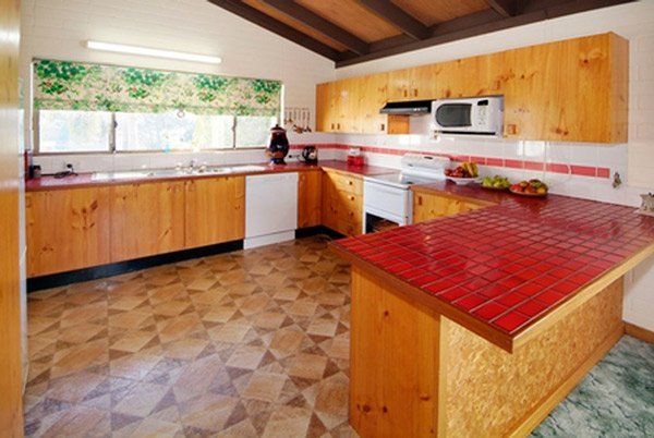 dated kitchen with wood cupboards and linoleum floor