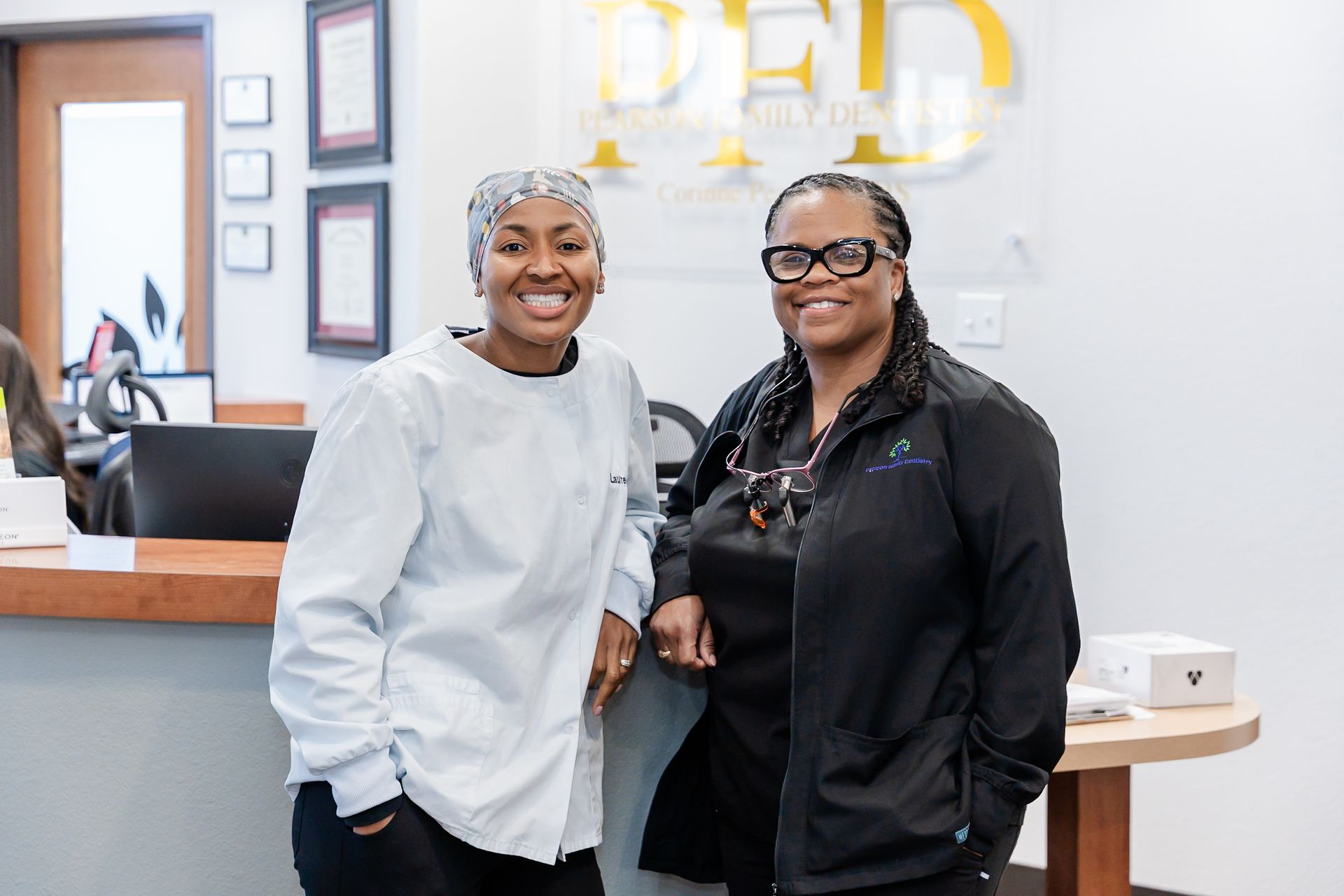 A woman is sitting in a dental chair talking to a dentist.