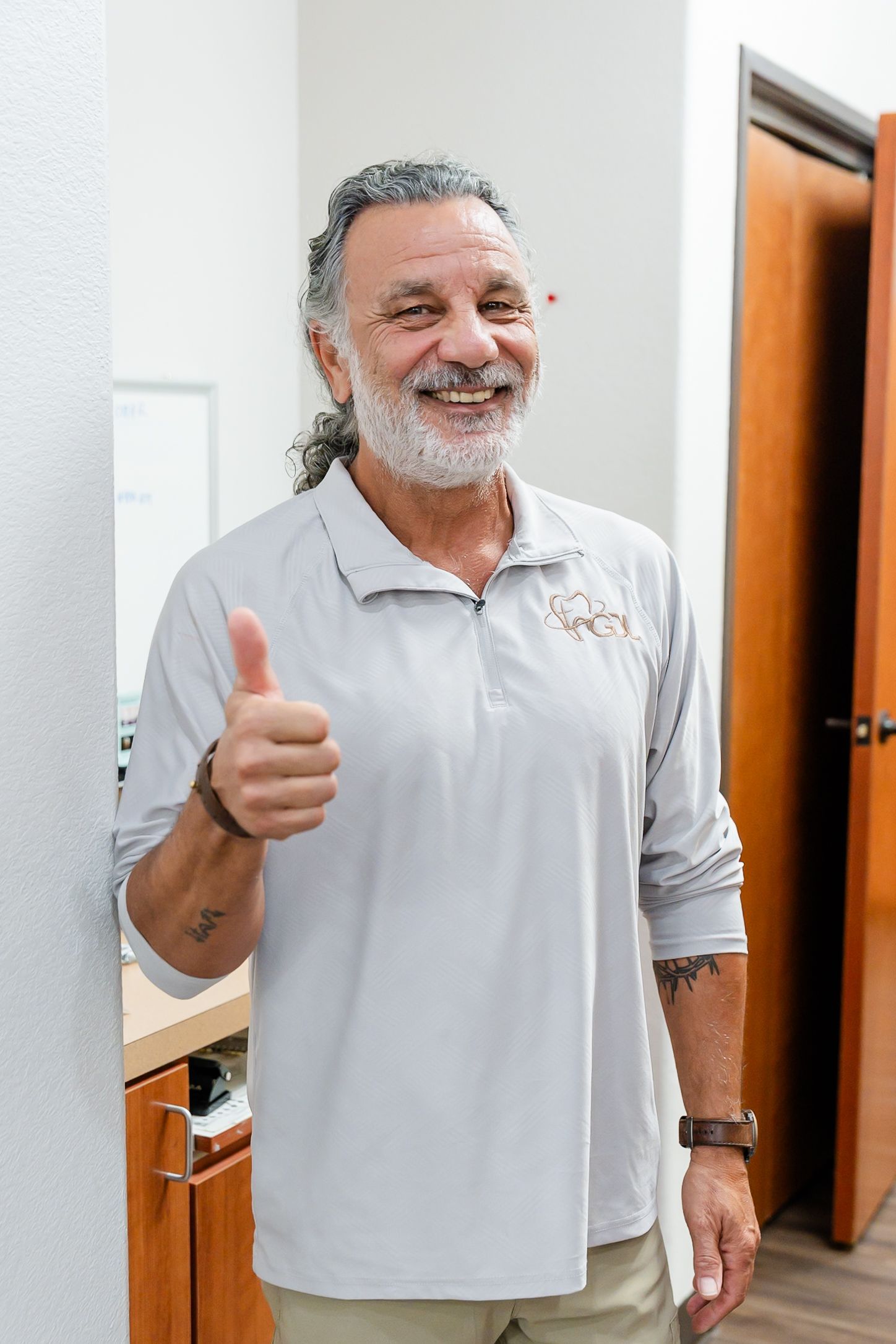 A man is smiling while looking at his teeth in a mirror.