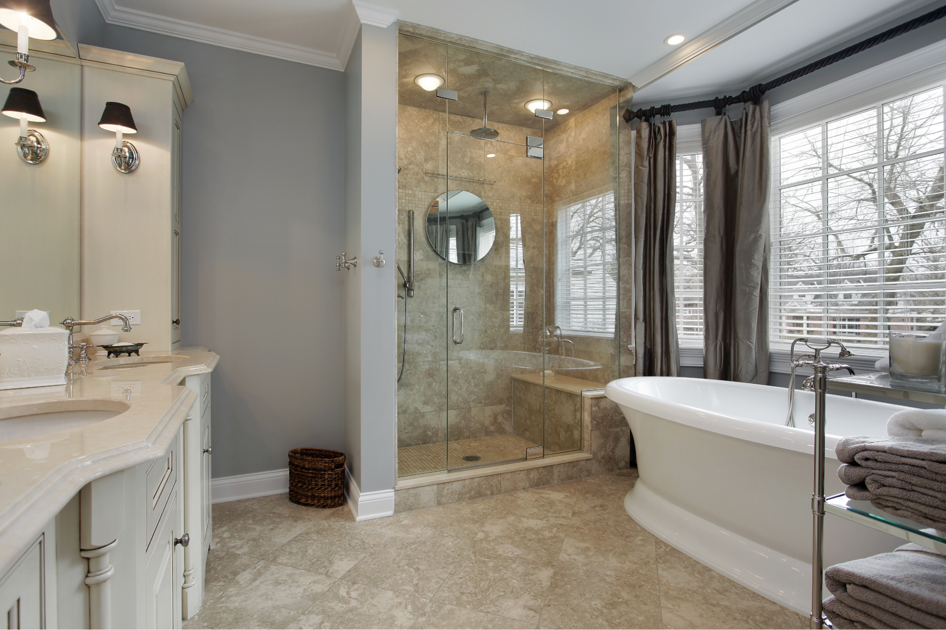 Elegant bathroom with a shower, bathtub, and vanity. Gray walls, beige tile floor, and large window.