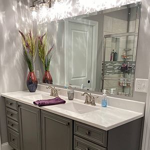 A bathroom with two sinks and a large mirror.