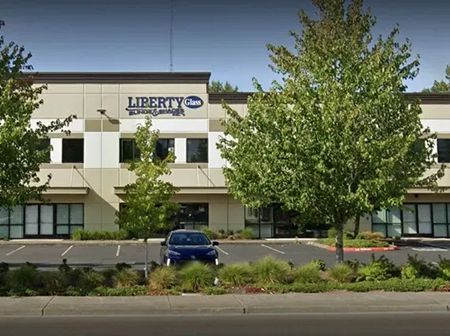 A blue car is parked in front of a liberty building