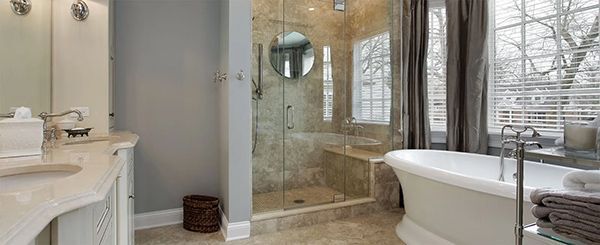 A bathroom with a tub , sink , shower and mirror.