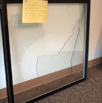 a broken glass window is sitting on a carpet next to a wall .