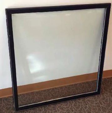 a window is sitting on a carpet next to a wall .