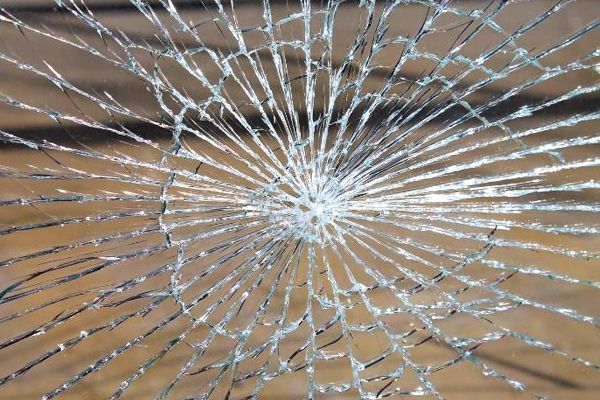 a close up of a broken glass on a wooden surface