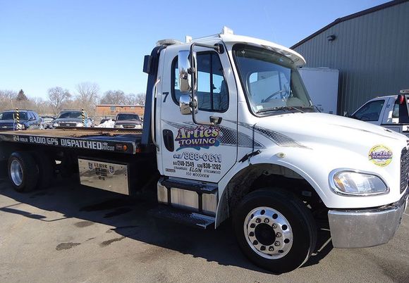 White Archer's Towing truck parked outside on a sunny day. The truck is white with black and gray details.