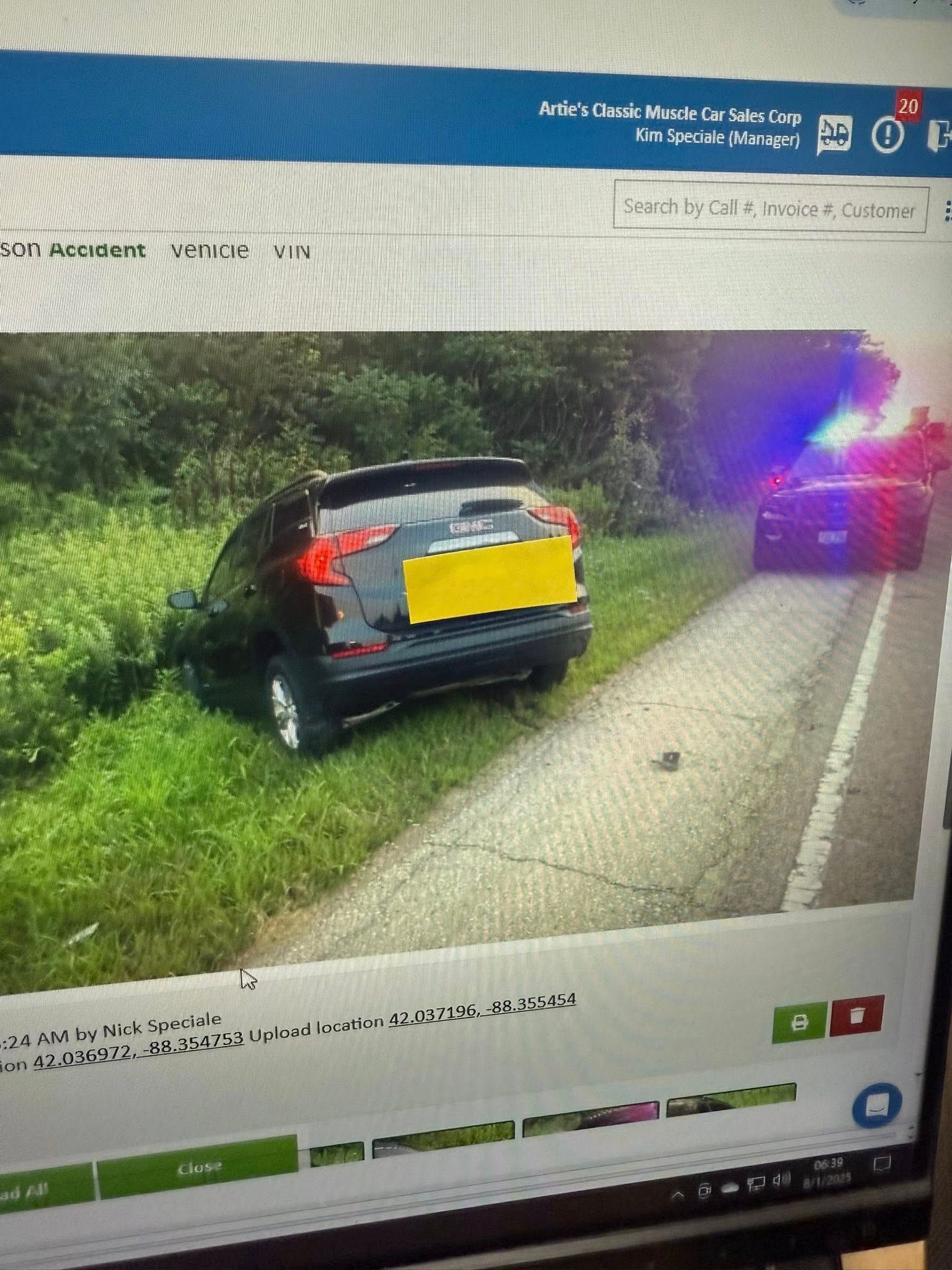 Black SUV on the side of a road with flashing police lights.