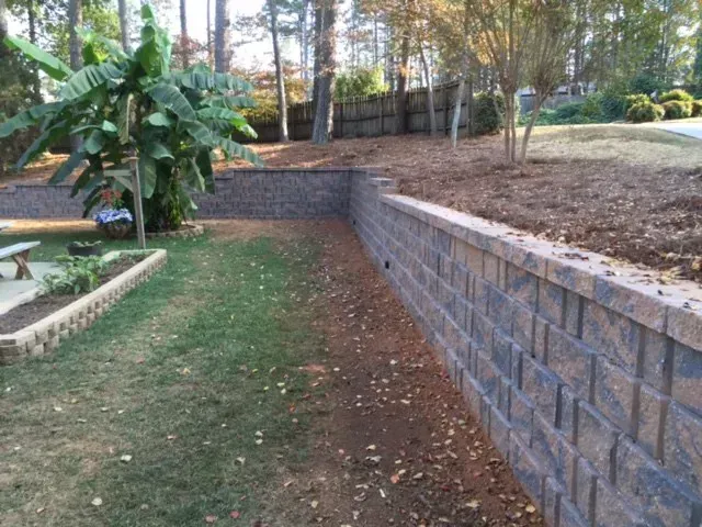A brick wall in the backyard of a house.