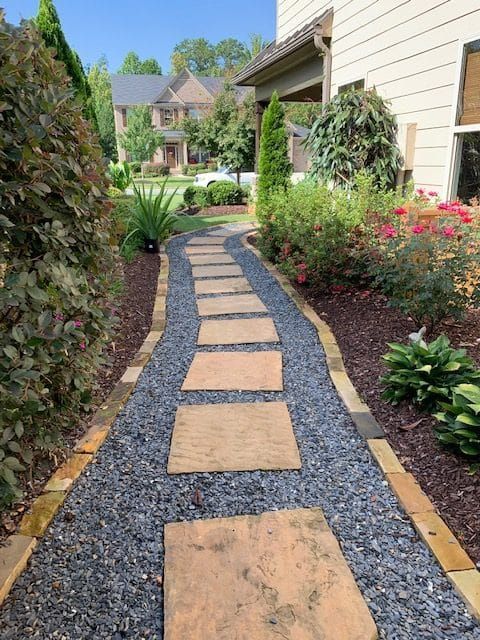 A stone walkway with a house in the background