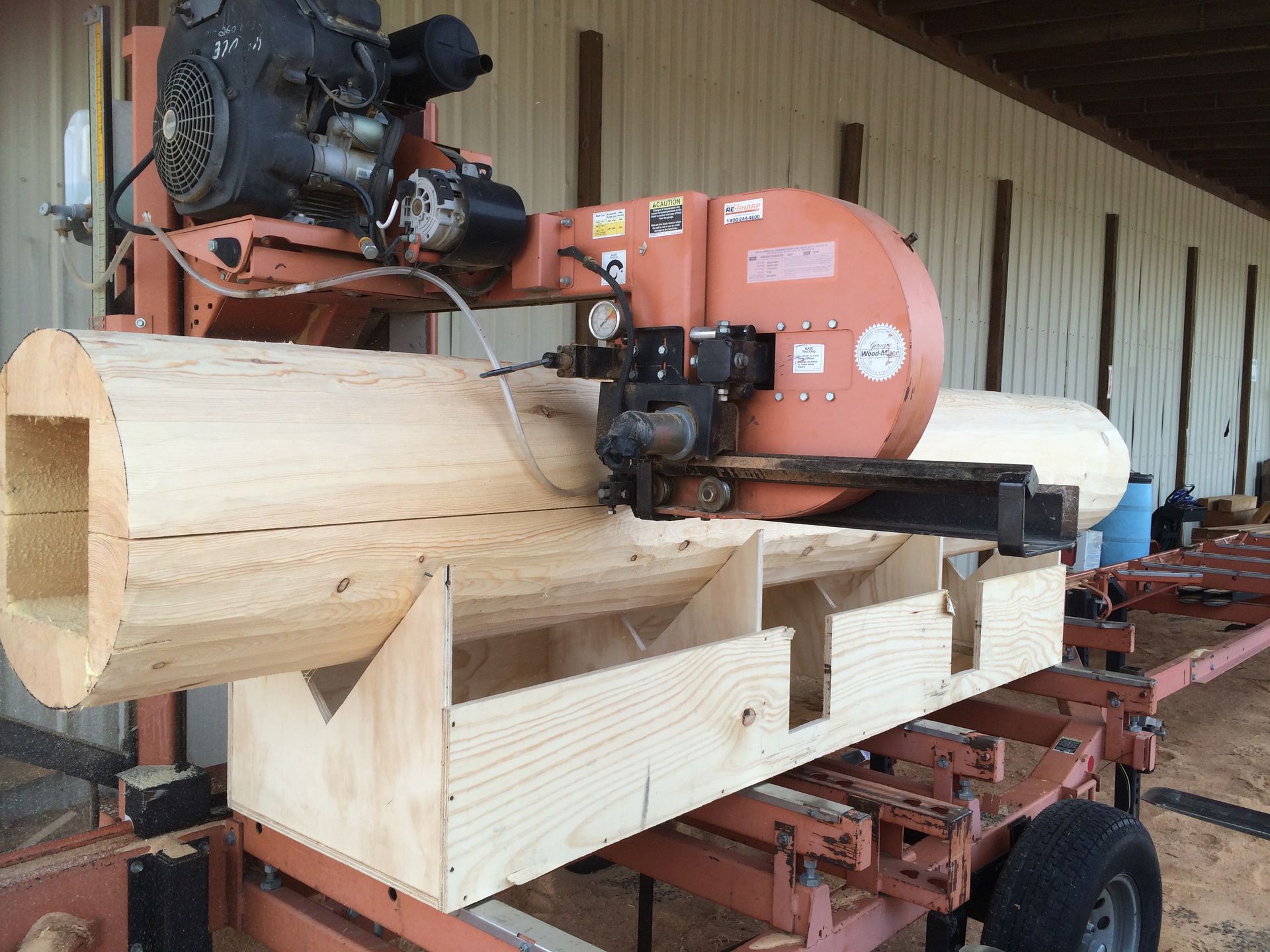 a saw cuts a false log carved to enclose a steel beam