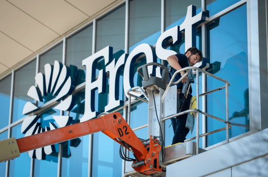 A worker in a bucket lift repairs the large