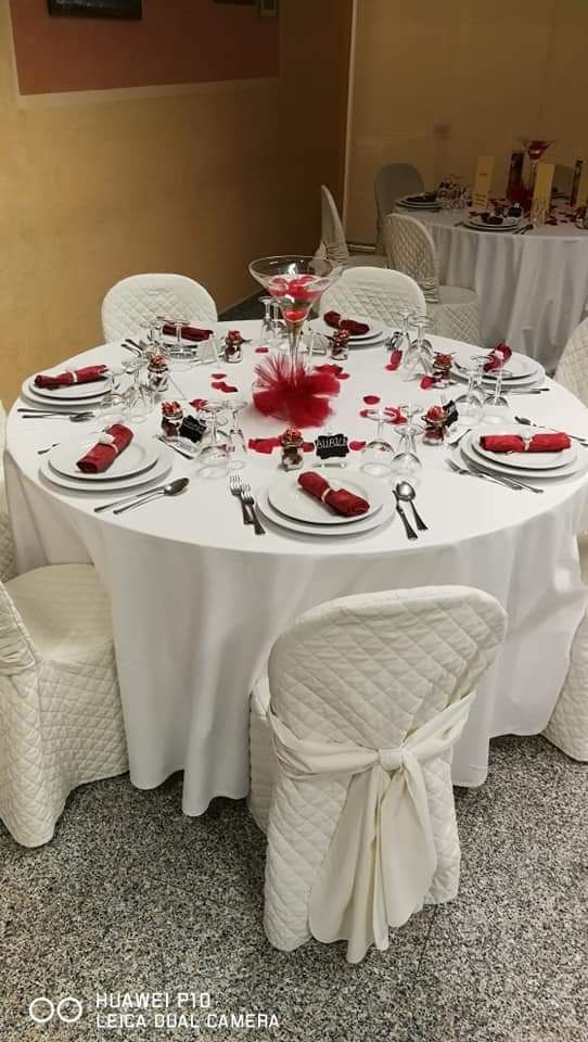 Un tavolo e delle sedie sono allestiti per un ricevimento di nozze.