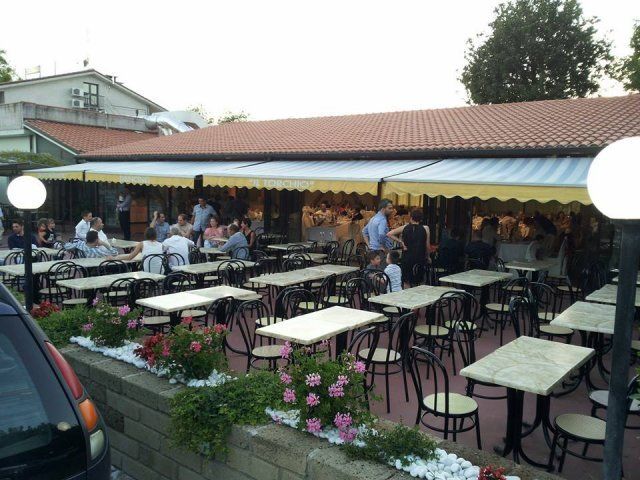 Un gruppo di persone sedute ai tavoli fuori da un ristorante