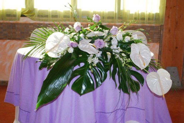 Un tavolo con una tovaglia viola e dei fiori sopra