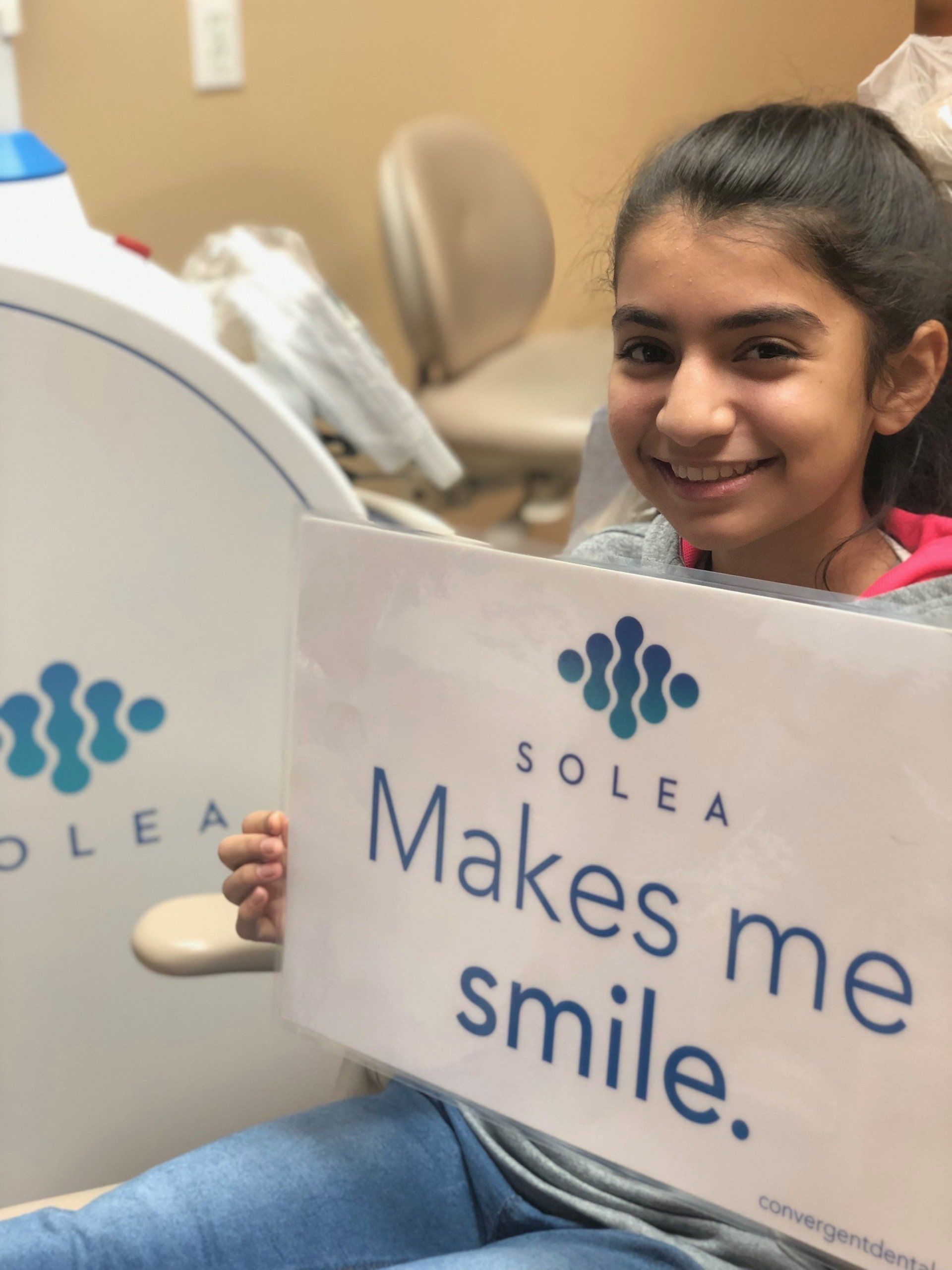 A girl holding a sign that says solea makes me smile