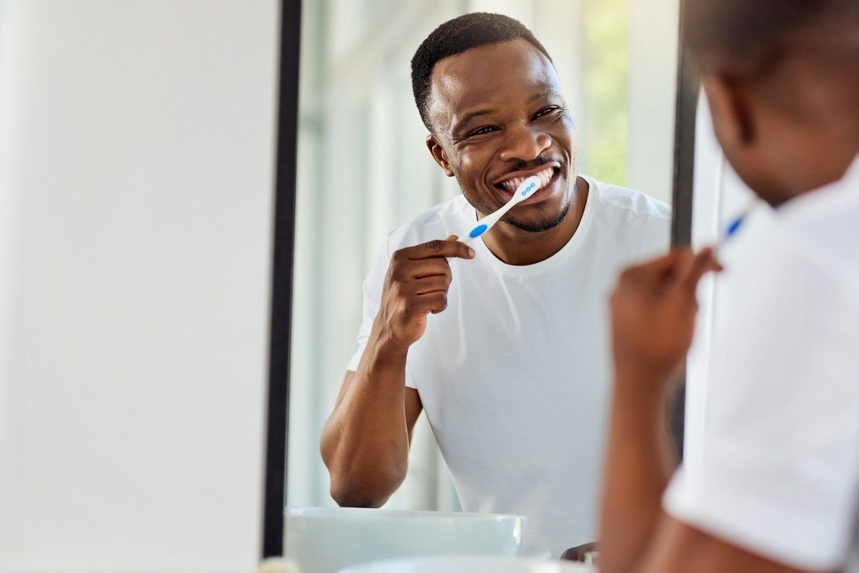 Man brushing his teeth in front of a mirror
