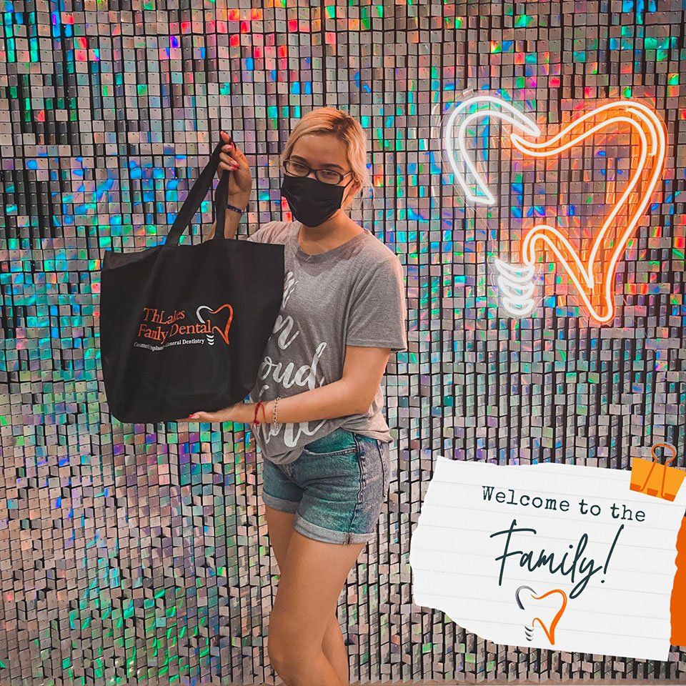 A woman wearing a mask is holding a black tote bag.