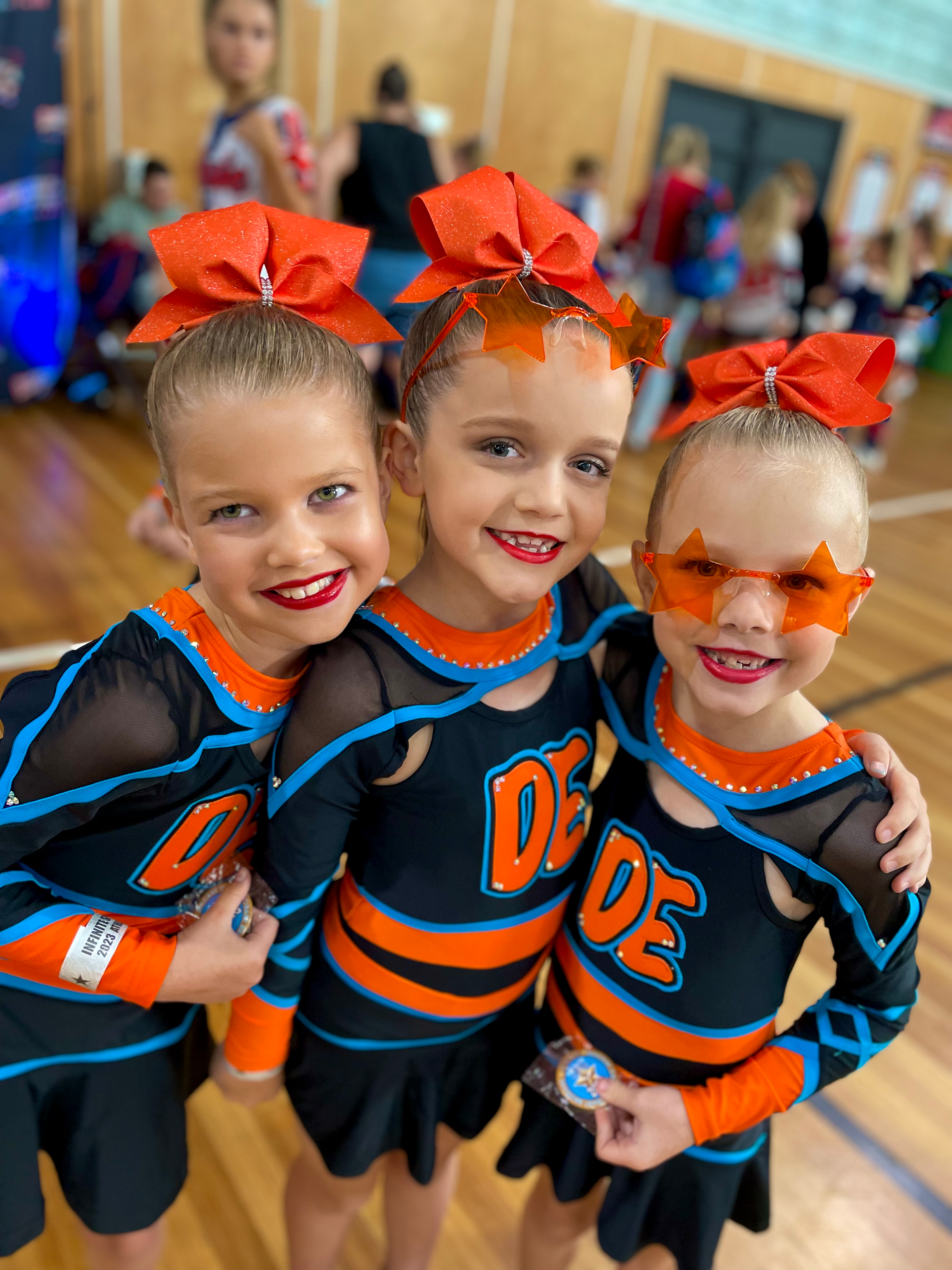 A Group Of Cheerleaders Are Posing For A Picture In Front Of A Building — Dance Express Mackay In North Mackay, QLD
