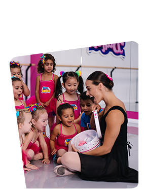 A Woman is Kneeling Down in Front of a Group of Little Girls in a Dance Studio — Dance Express Mackay In North Mackay, QLD
