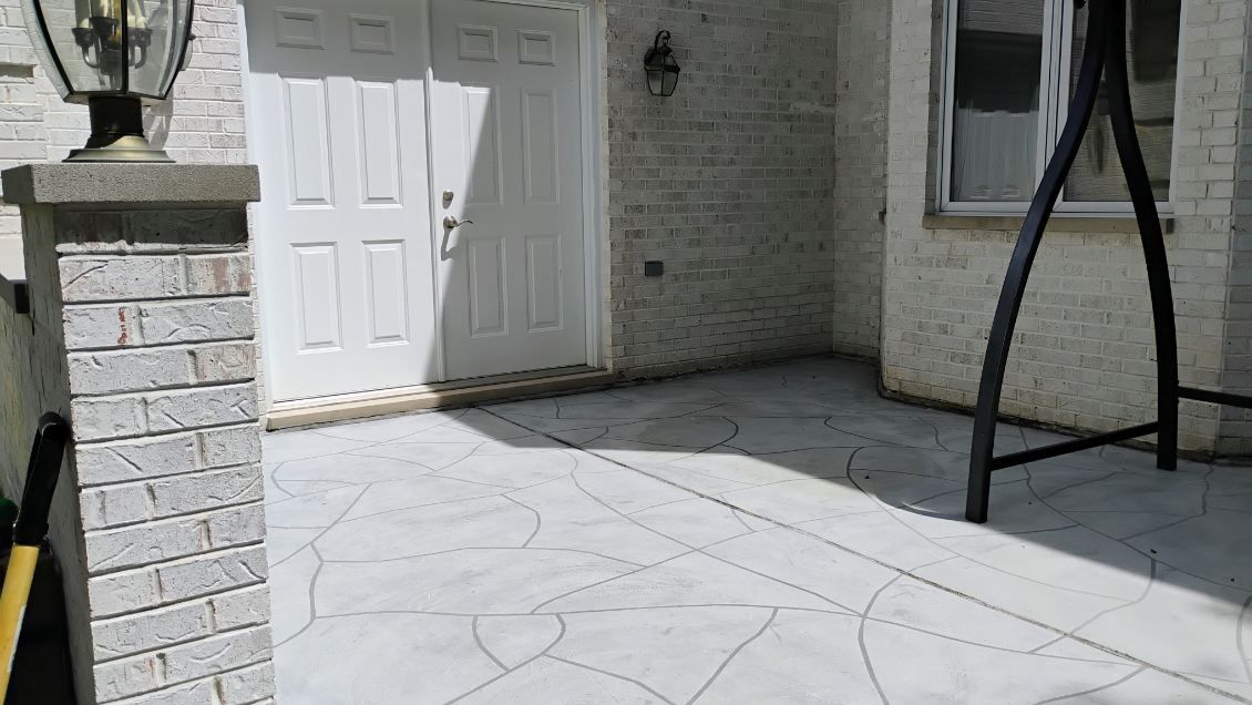 A white brick house with a swing set in front of it.