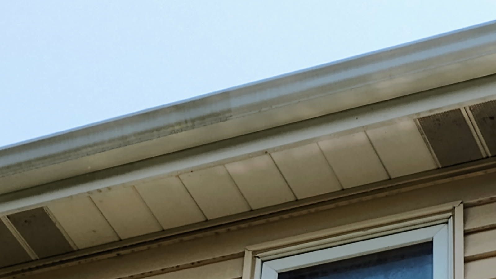 A close up of the roof of a house with a window.