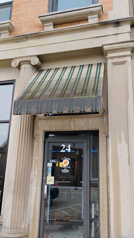 The front door of a building with a canopy over it.