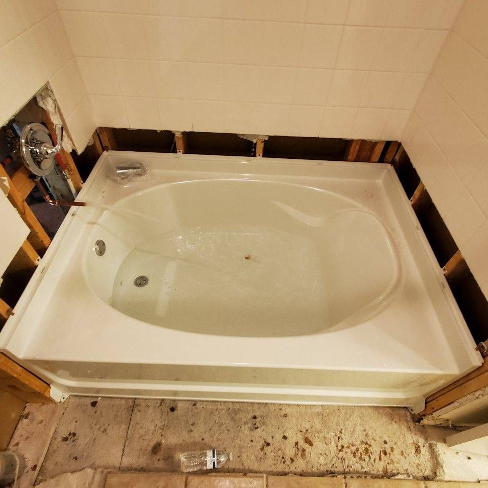 A bathtub in a bathroom that is being remodeled