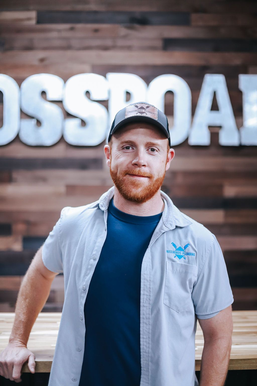 A man and two children are standing in front of a plumbing truck.