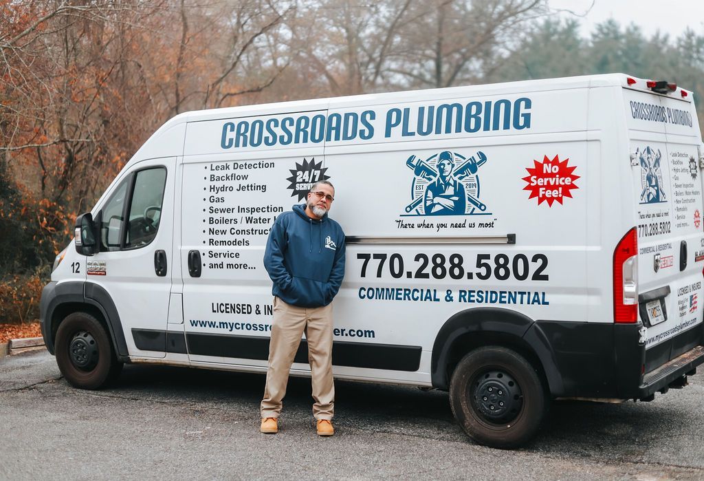 A plumber is fixing a sink in a kitchen.