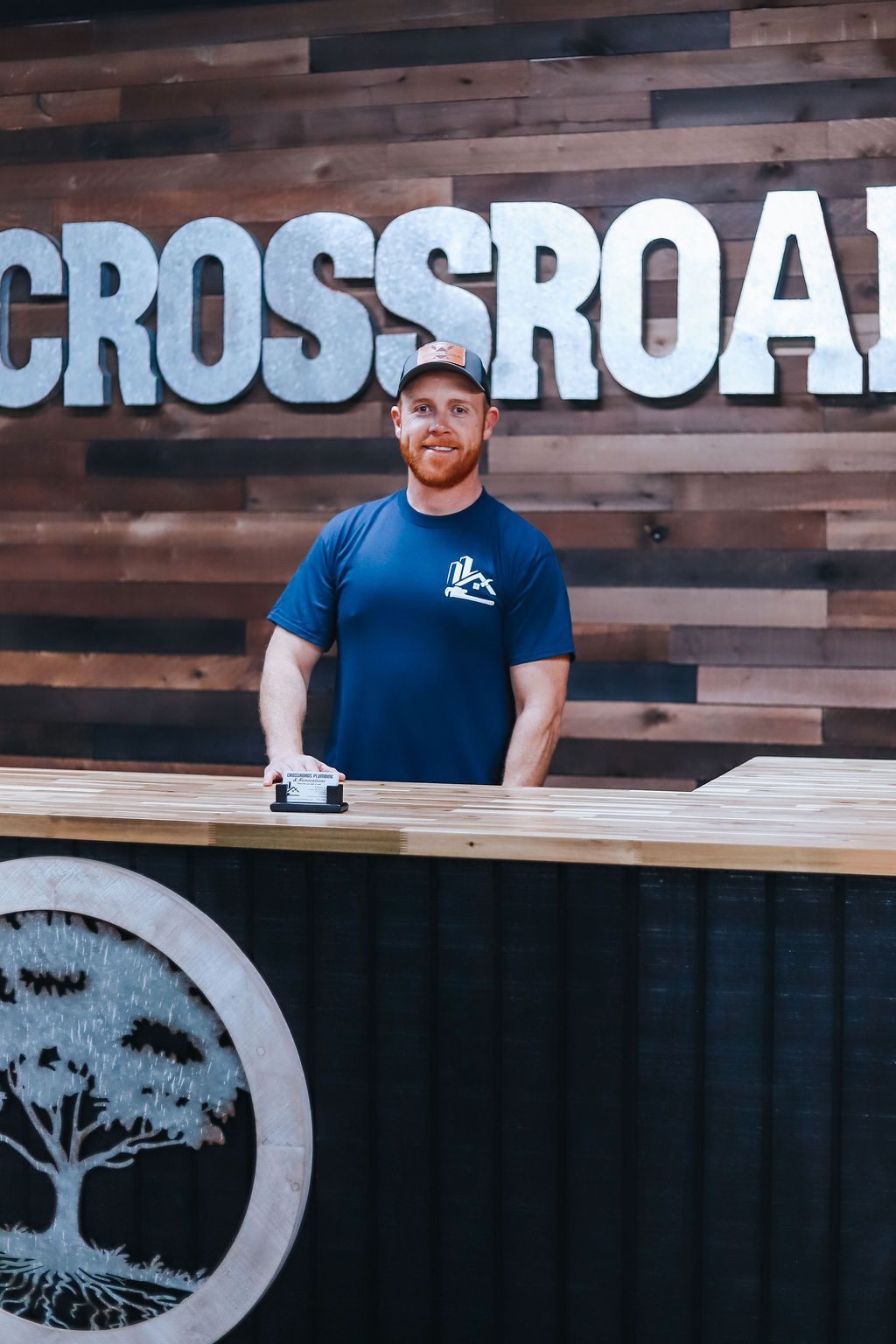 A man standing in front of a crossroads plumbing van