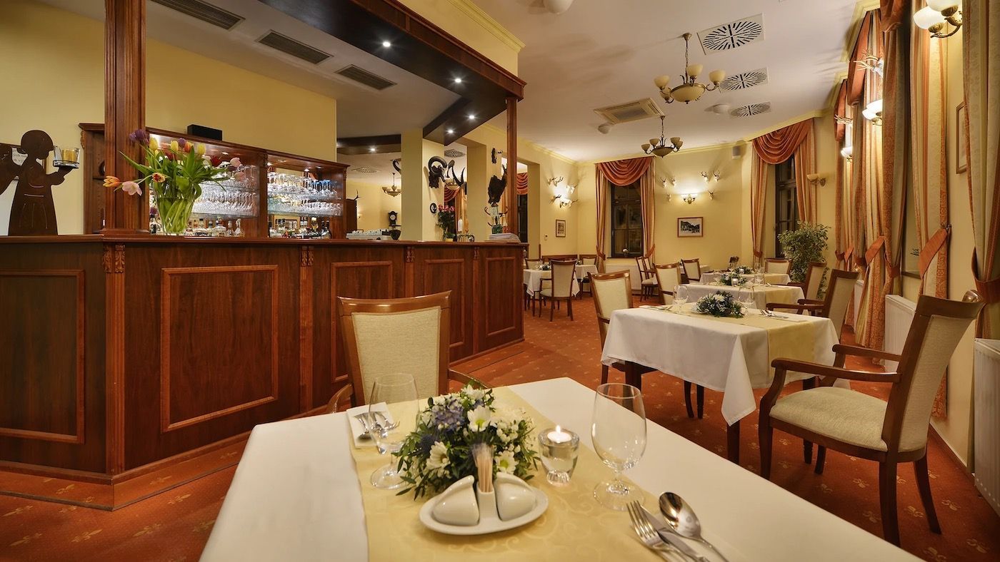 A restaurant with tables and chairs and a bar.