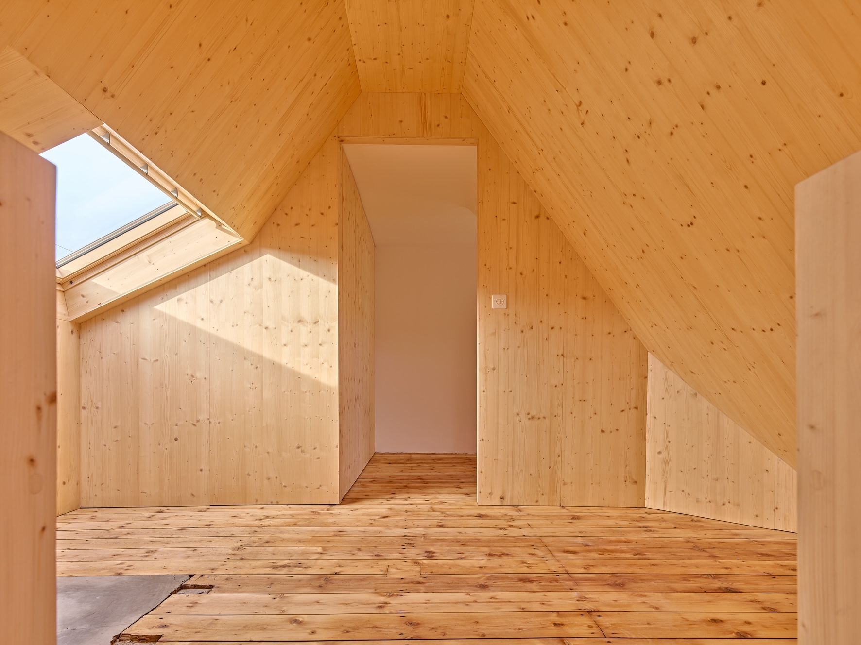 Ein grosser leerer Raum mit Holzboden und Backsteinwänden.