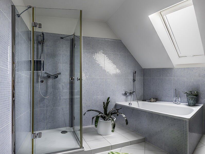 A bathroom shower with a glass semi frameless shower screen
