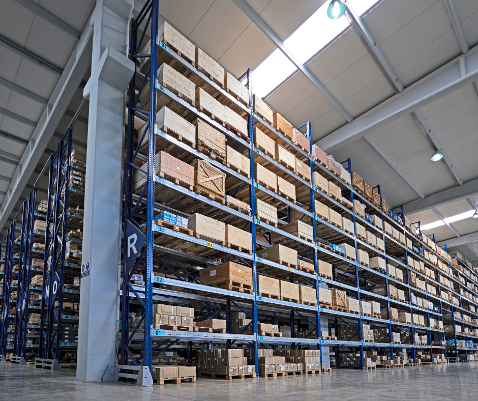 Warehouse interior with rows of shelves stacked with cardboard boxes.
