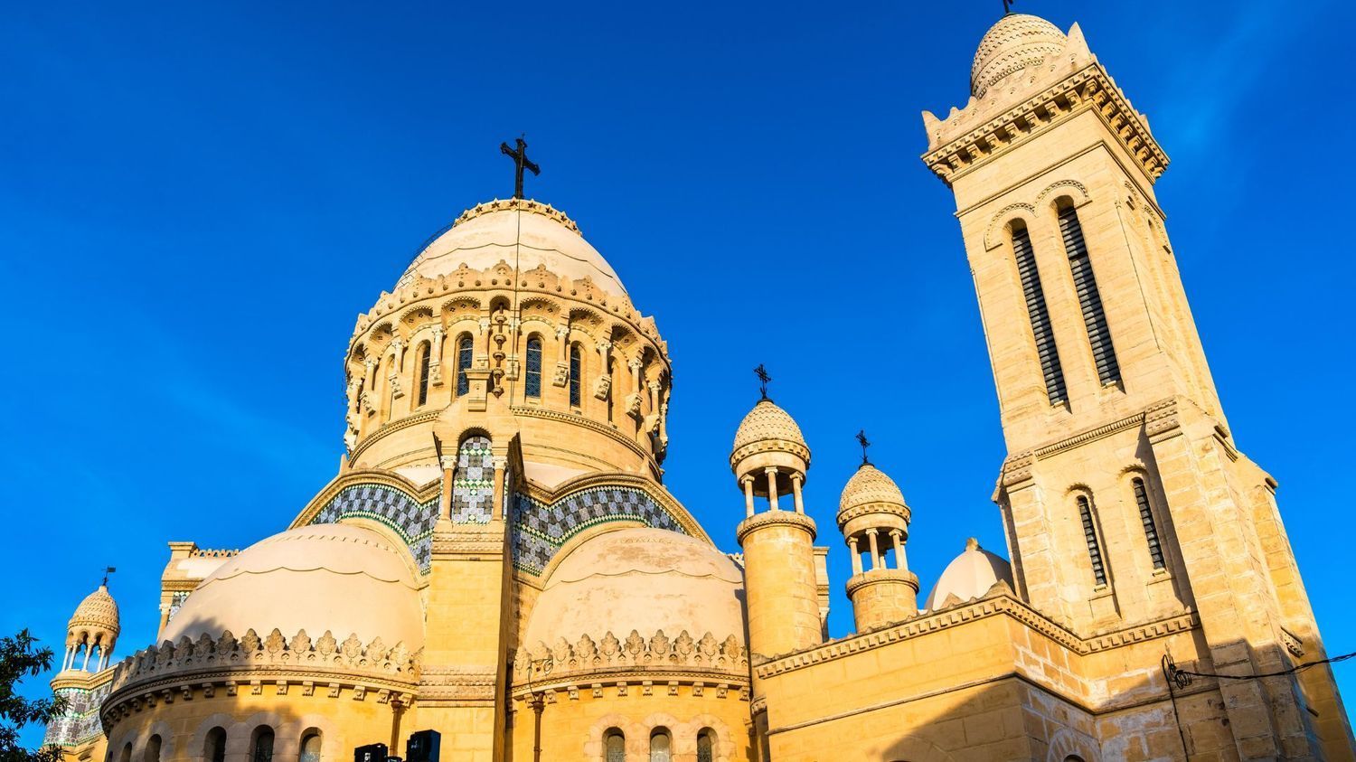 The Basilica of Our Lady of Africa in Algiers, a golden-toned, neo-Byzantine church with a large dome and a bell tower.