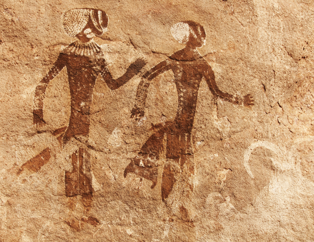 Rock painting of two figures in profile, adorned with elaborate headdresses and garments, depicted in a brown pigment.