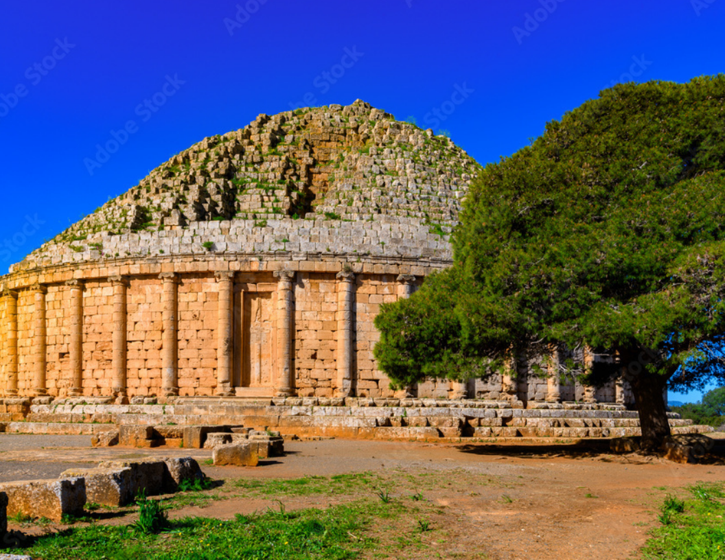 The Royal Mausoleum of Mauretania, an ancient stone circular monument with columns under a bright blue sky.