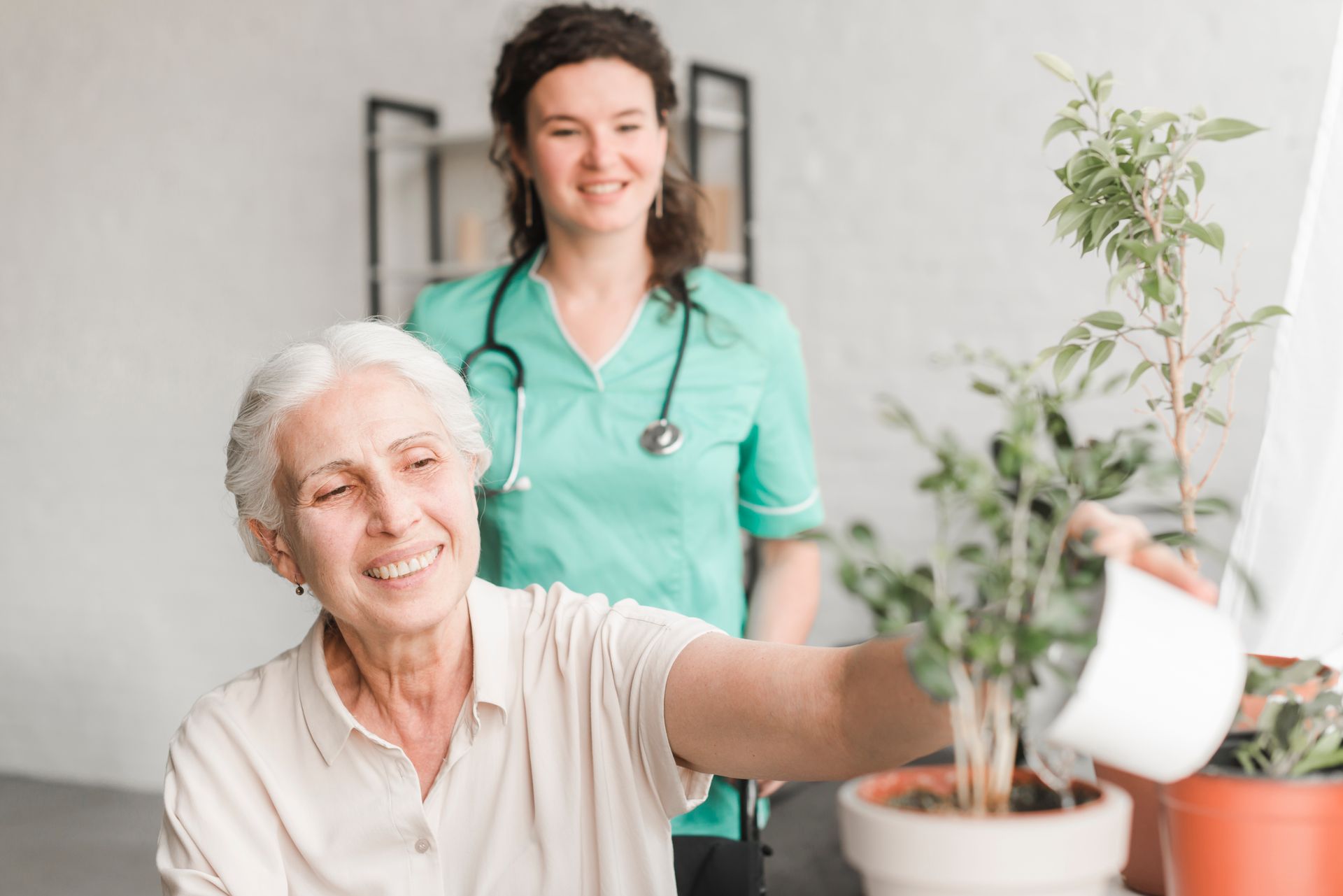 Older lady watering the plants with supervision from Occupational Therapist.
