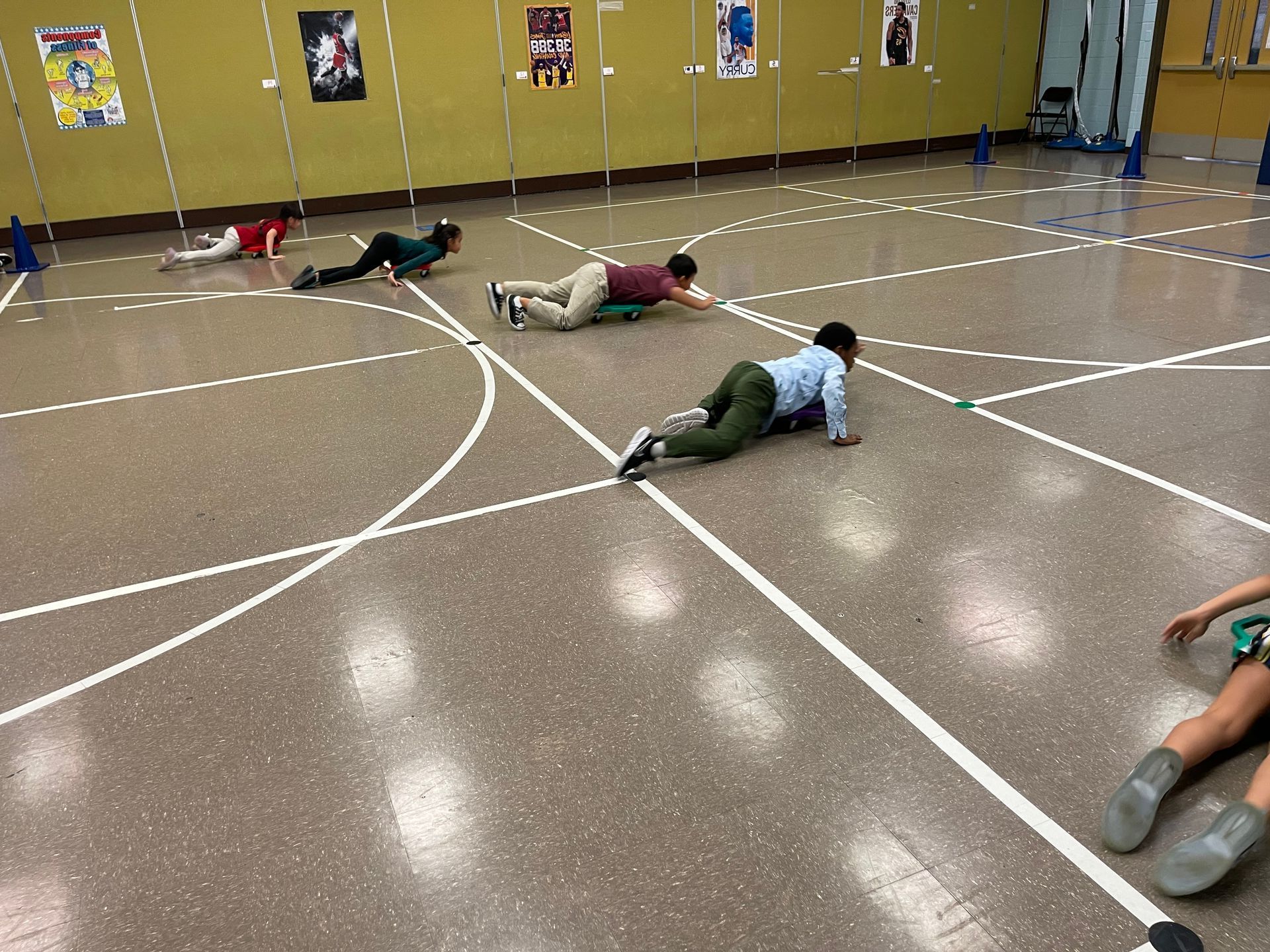 a group of people are crawling on the floor of a gym .