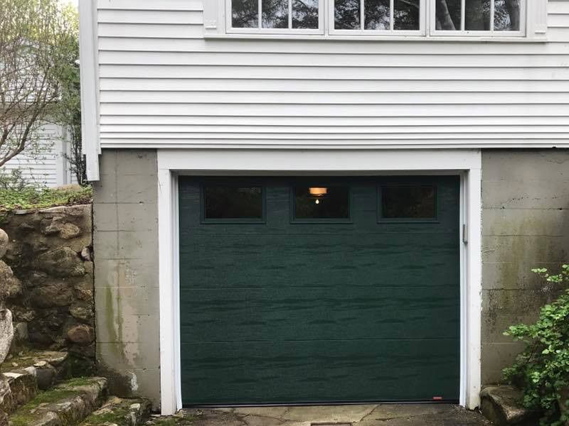 A white house with a green garage door