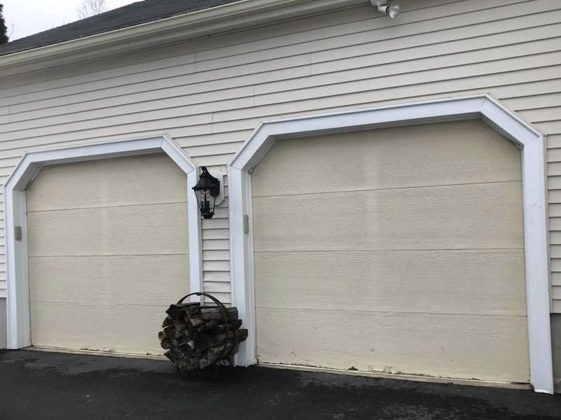 A couple of garage doors with arches on the side of a house