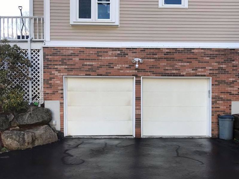 A house with two garage doors and a black driveway