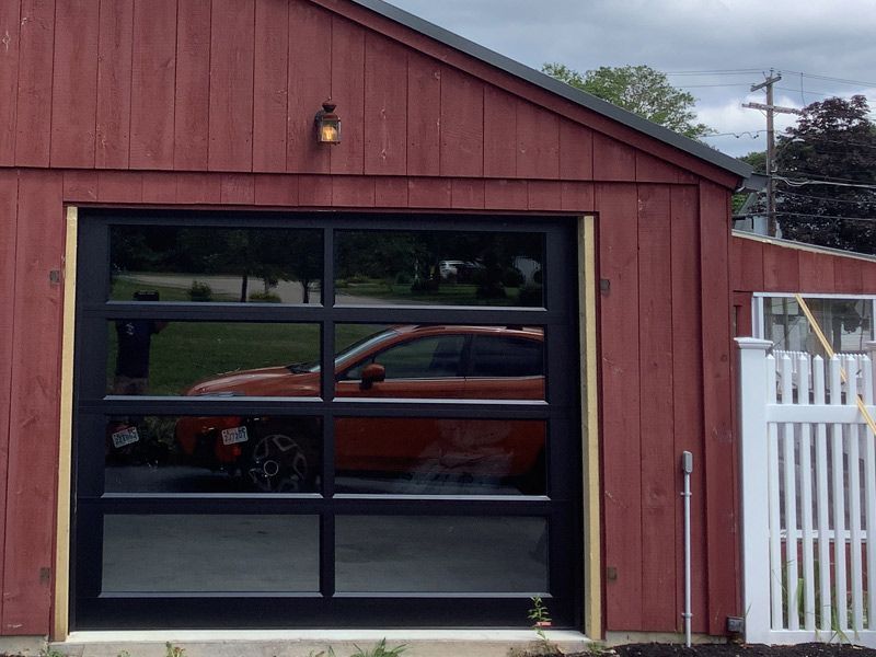 A red garage with a car parked in it